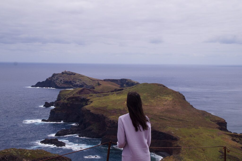 Woman on a viewpoint looking out into the ocean.