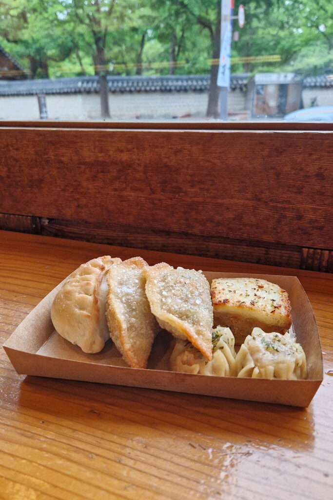 various dumplings on a piece of paper on wooden table
