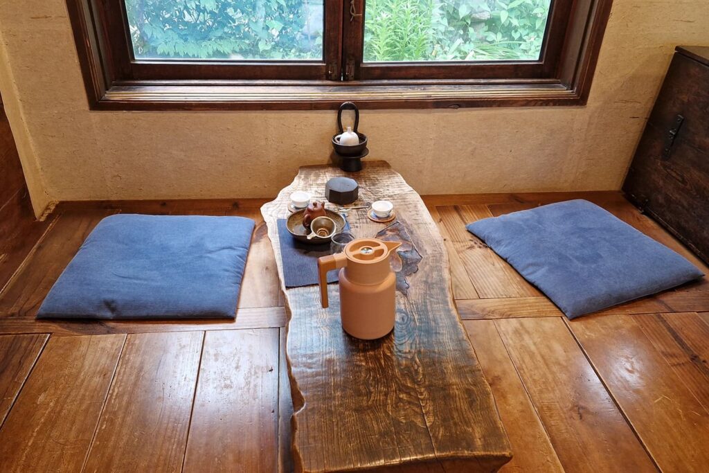 table and cushions in front of a window inside traditional Korean tea house in Jeonju Hanok Village