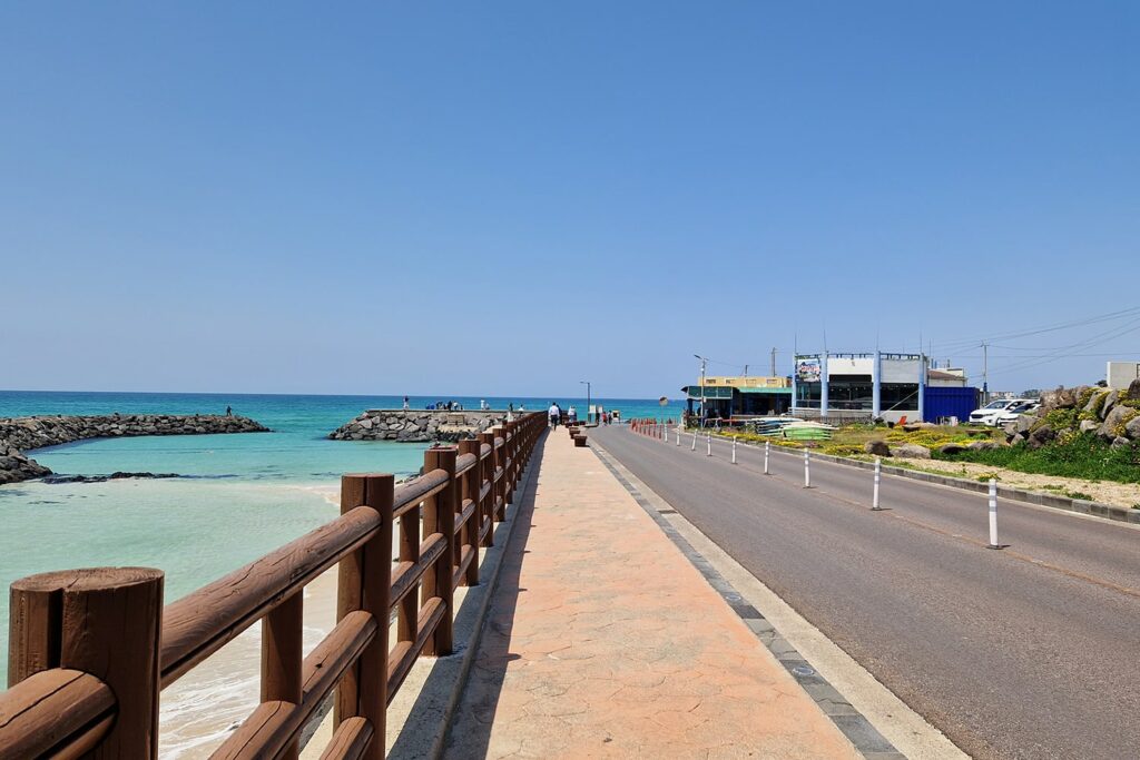 Stunning coastal road on Jeju island with crystal clear blue water in the background