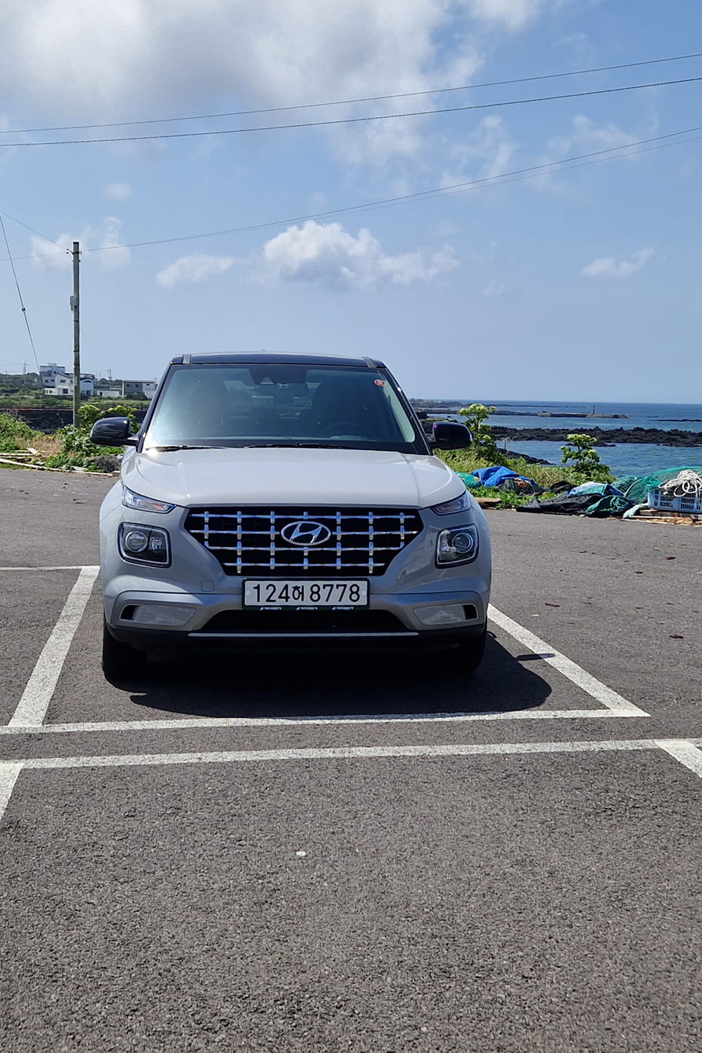 rental car standing on a parking lot next to the sea