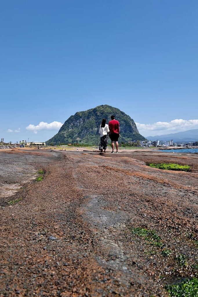 couple standing on Sagye beach in front of Sanbang Mountain Jeju