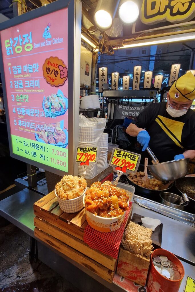 man cooking tangerine flavored fried chicken at his food stall on Dongmun nightmarket