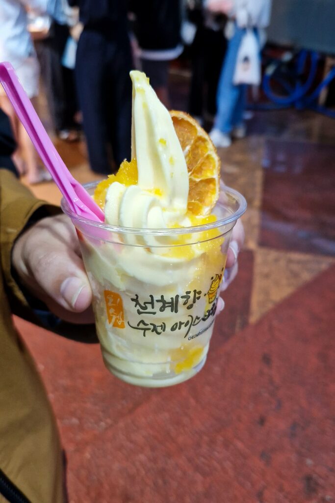 hand holding cup of tangerine flavored ice cream