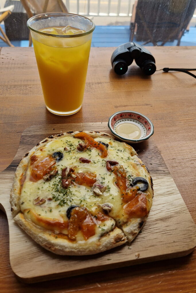 tangerine pizza on wooden tray with orange juice on the side