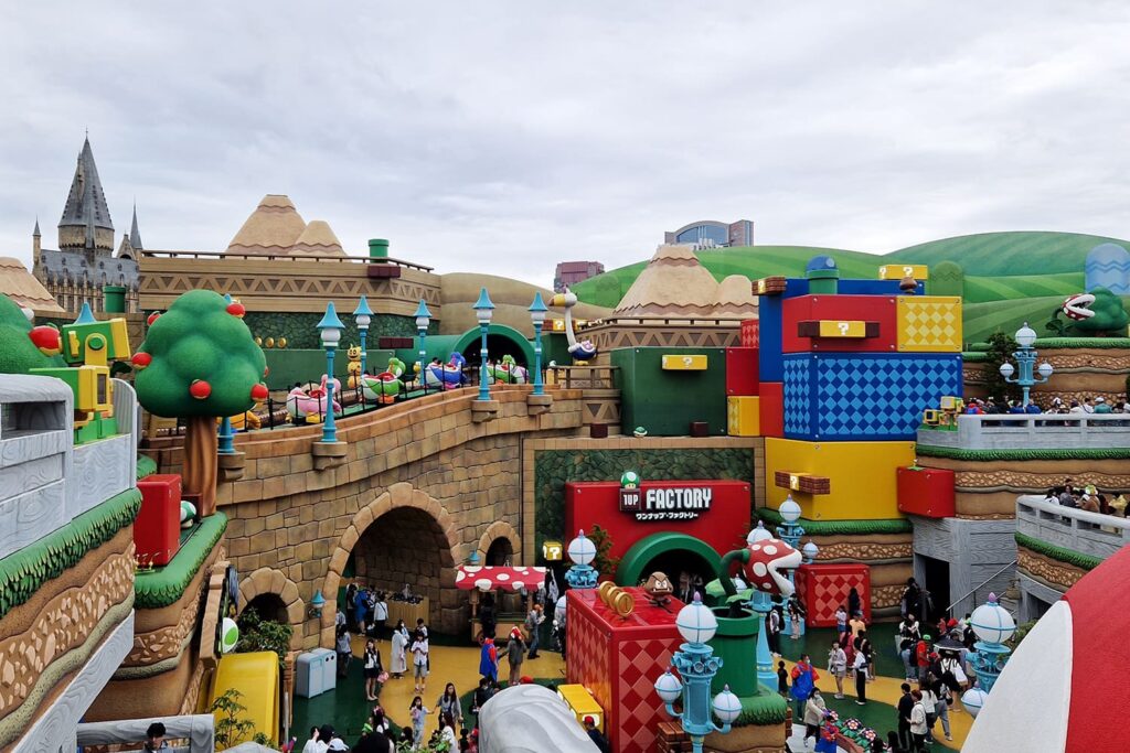 Nintendo World in Universal Studios Osaka with Peaches Castle and a lot of people waiting at the attractions.