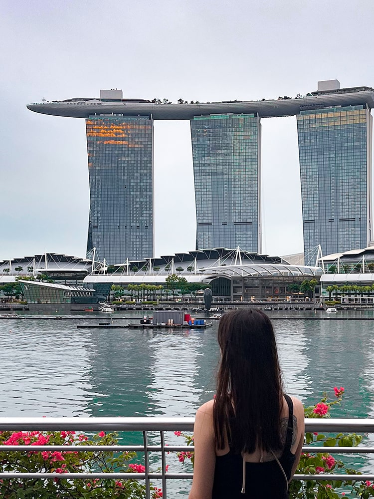 woman standing in front of Marina bay looking at Marina Bay Sands Hotel.