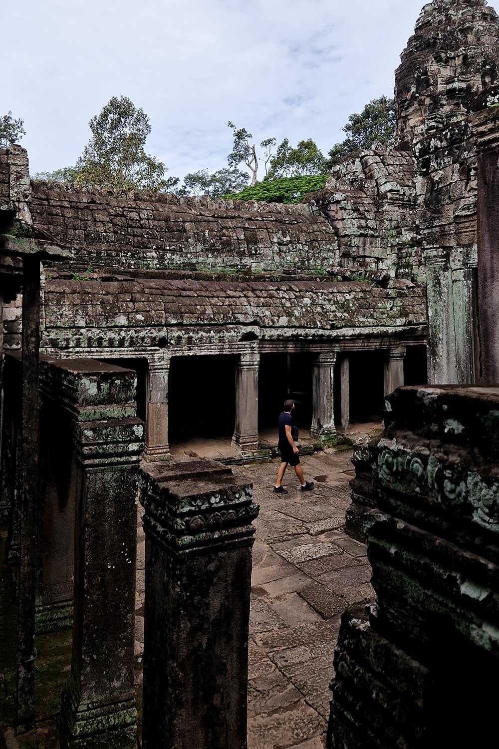 Boy walking through the old Bayon temple in the Angkor Wat Archeological Park.