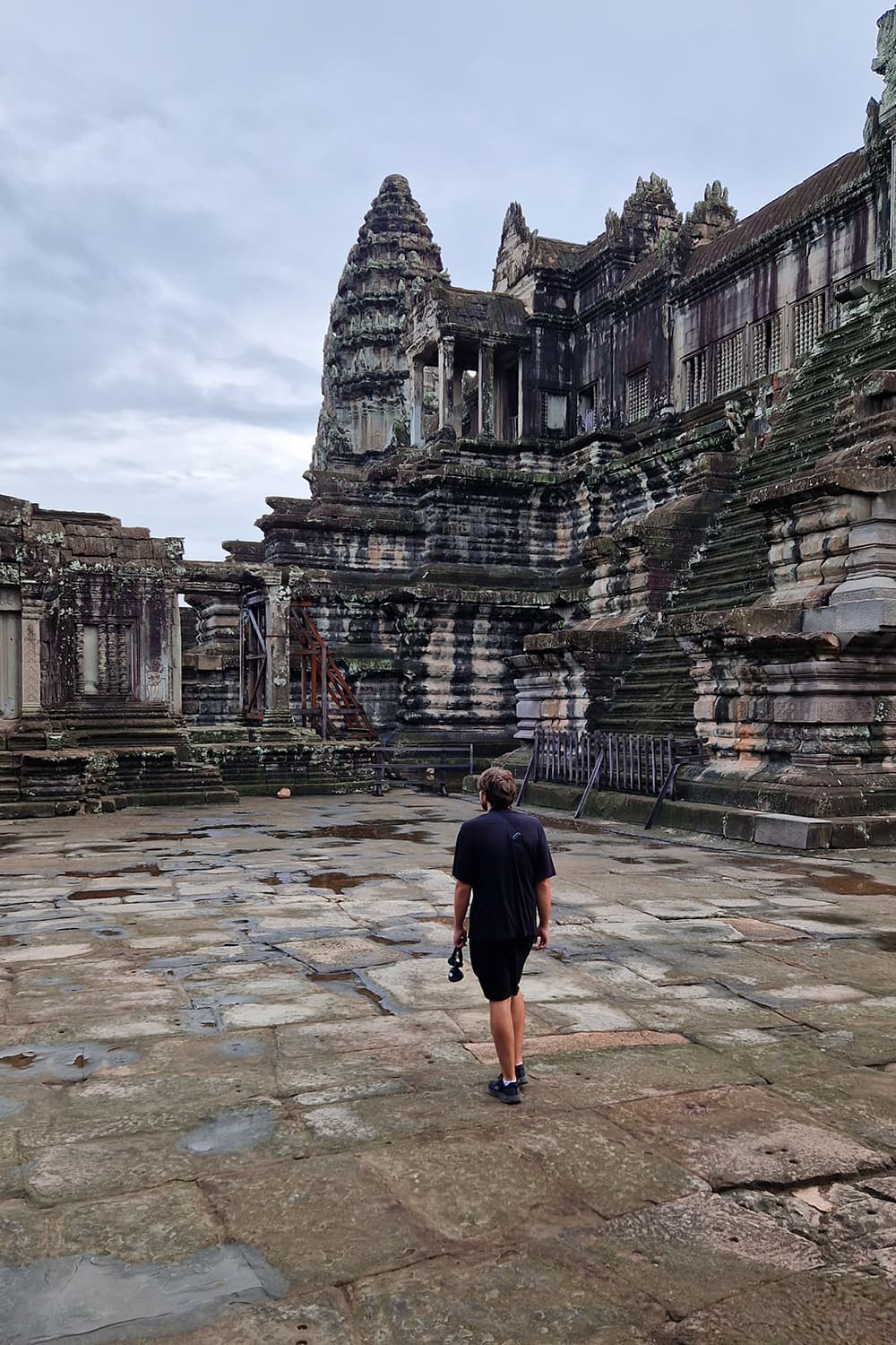 Man walking through an empty Angkor Wat temple.