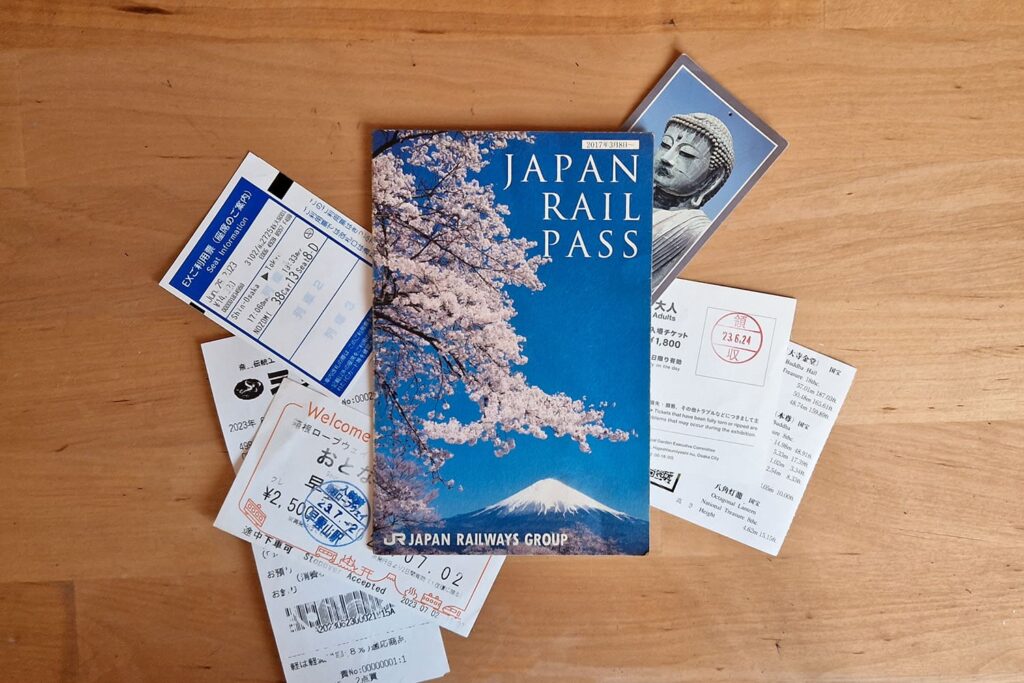 A japanese rail pass with a picture of a blossoming sakura tree in front of Mount Fuji.