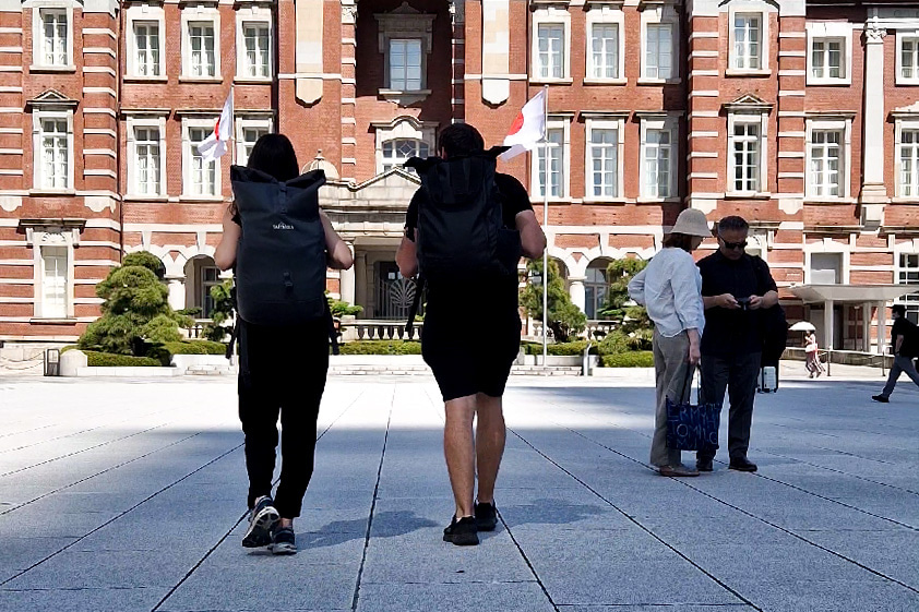 A couple with backpacks walking towards Tokyo Station.