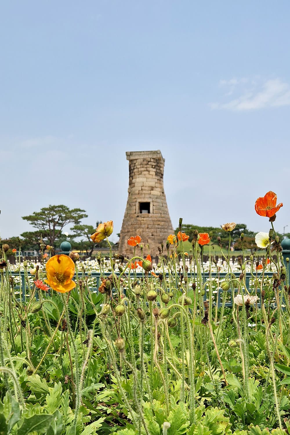 A very old observatory tower surrounded by flowers.