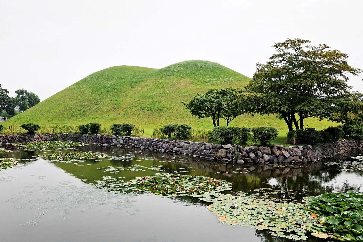 A grass hill with a tomb underneath it.