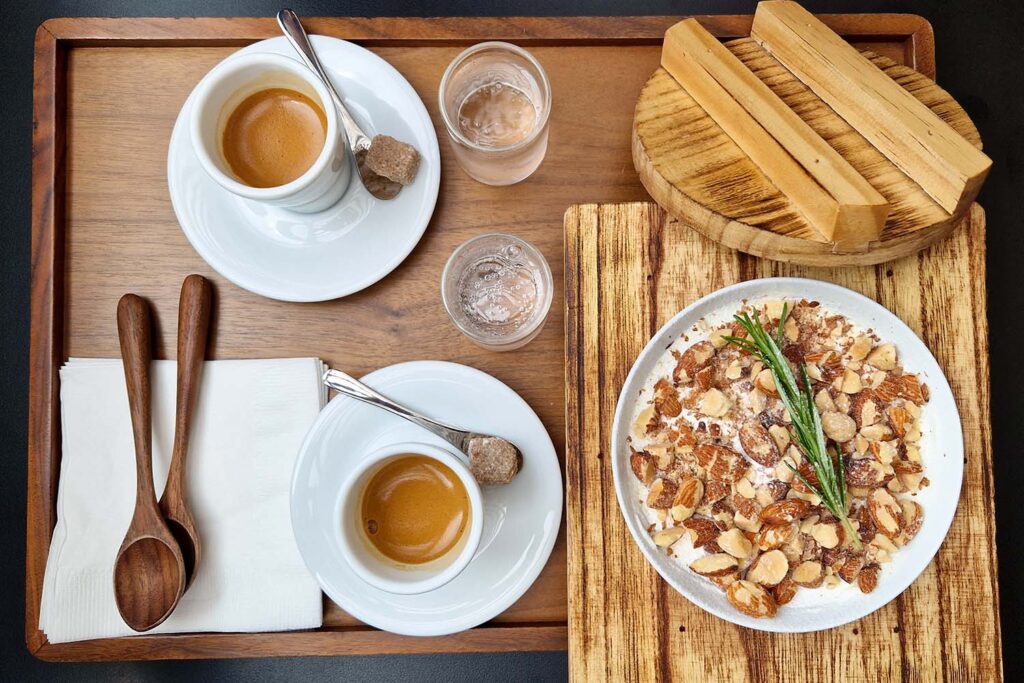 A tray with two coffees and a tiramisu.