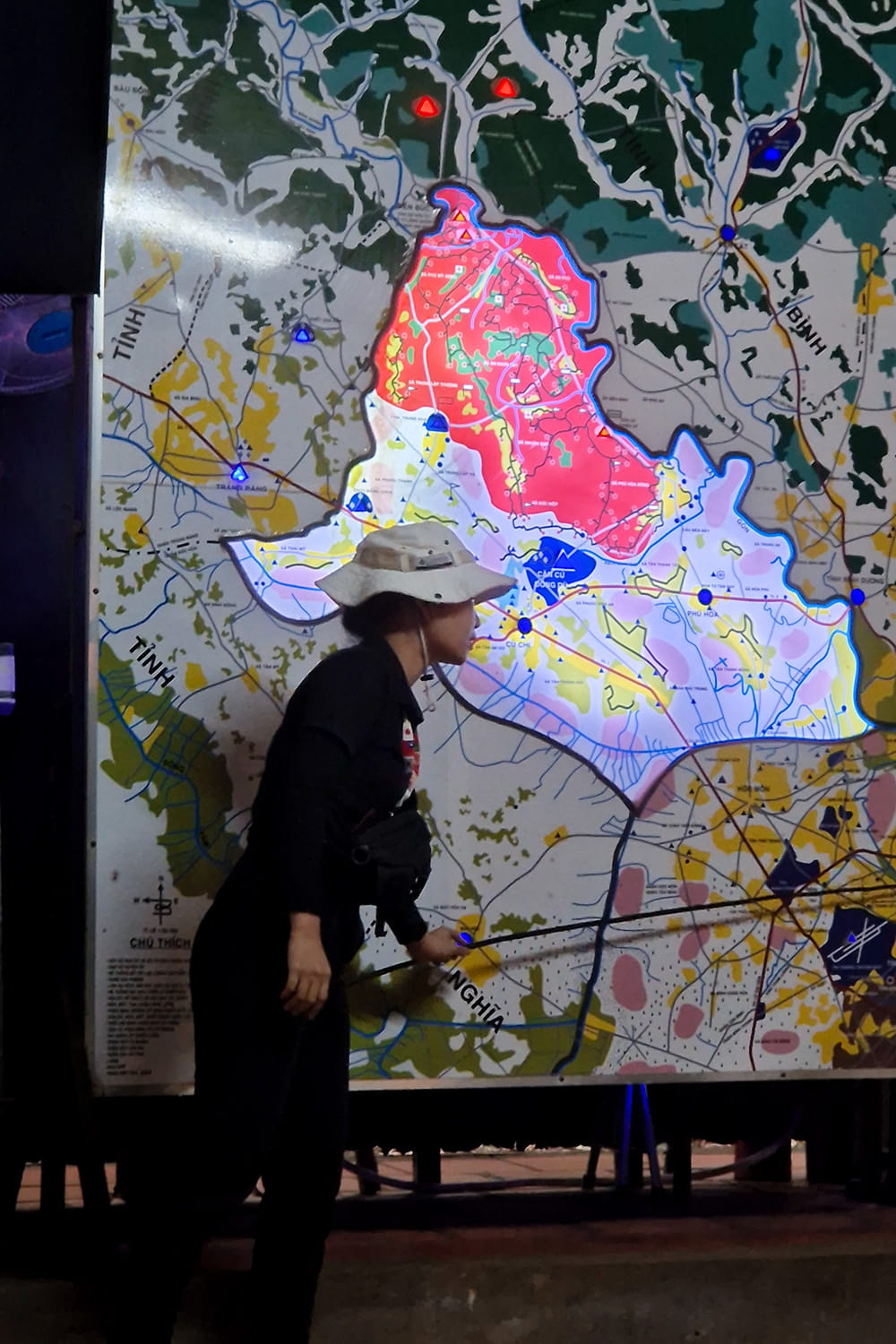 A map of the cu-chi tunnels in vietnam with a guide standing in front of the map explaining the history of the tunnels.