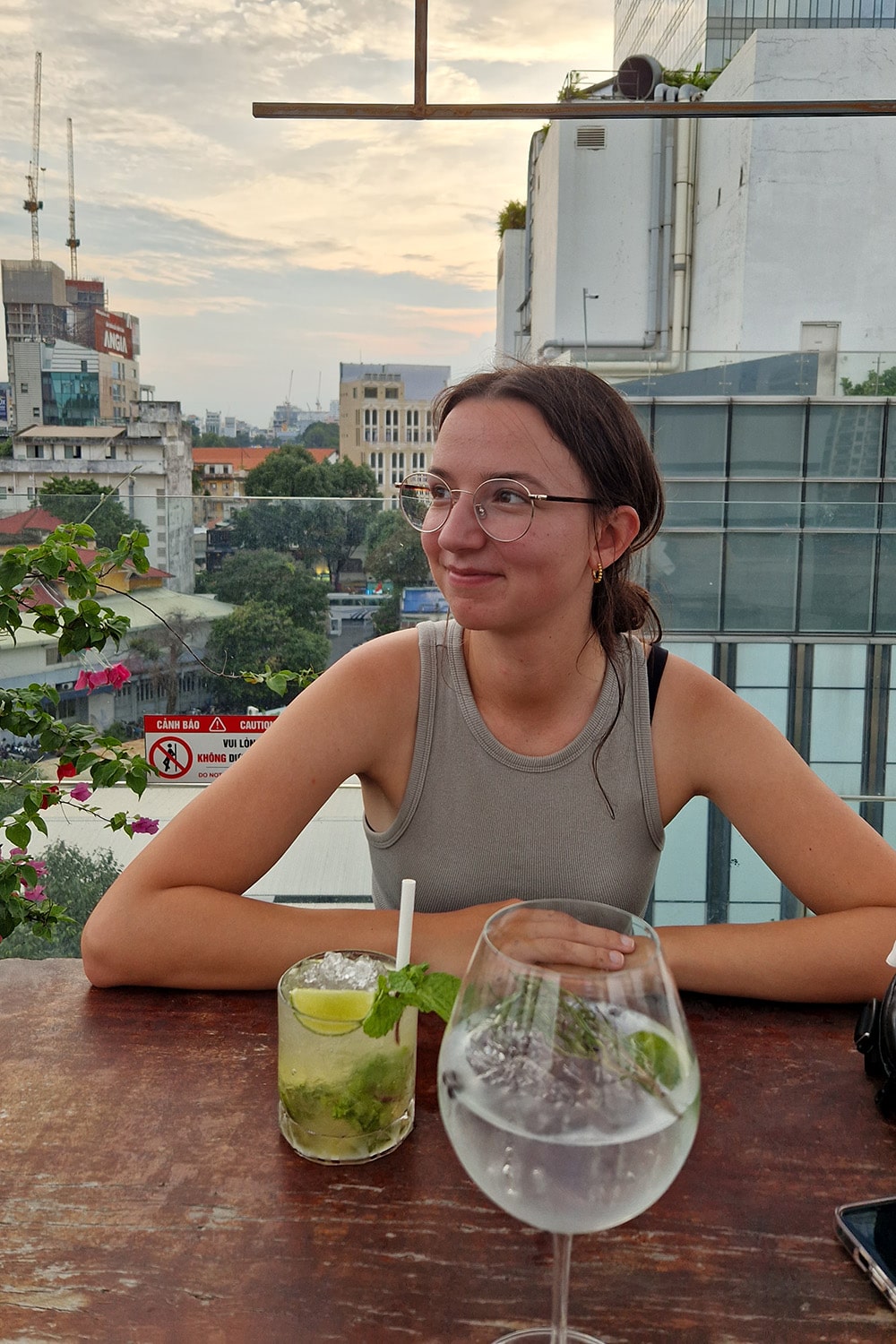 Woman sitting in a rooftop bar drinking a cocktail.