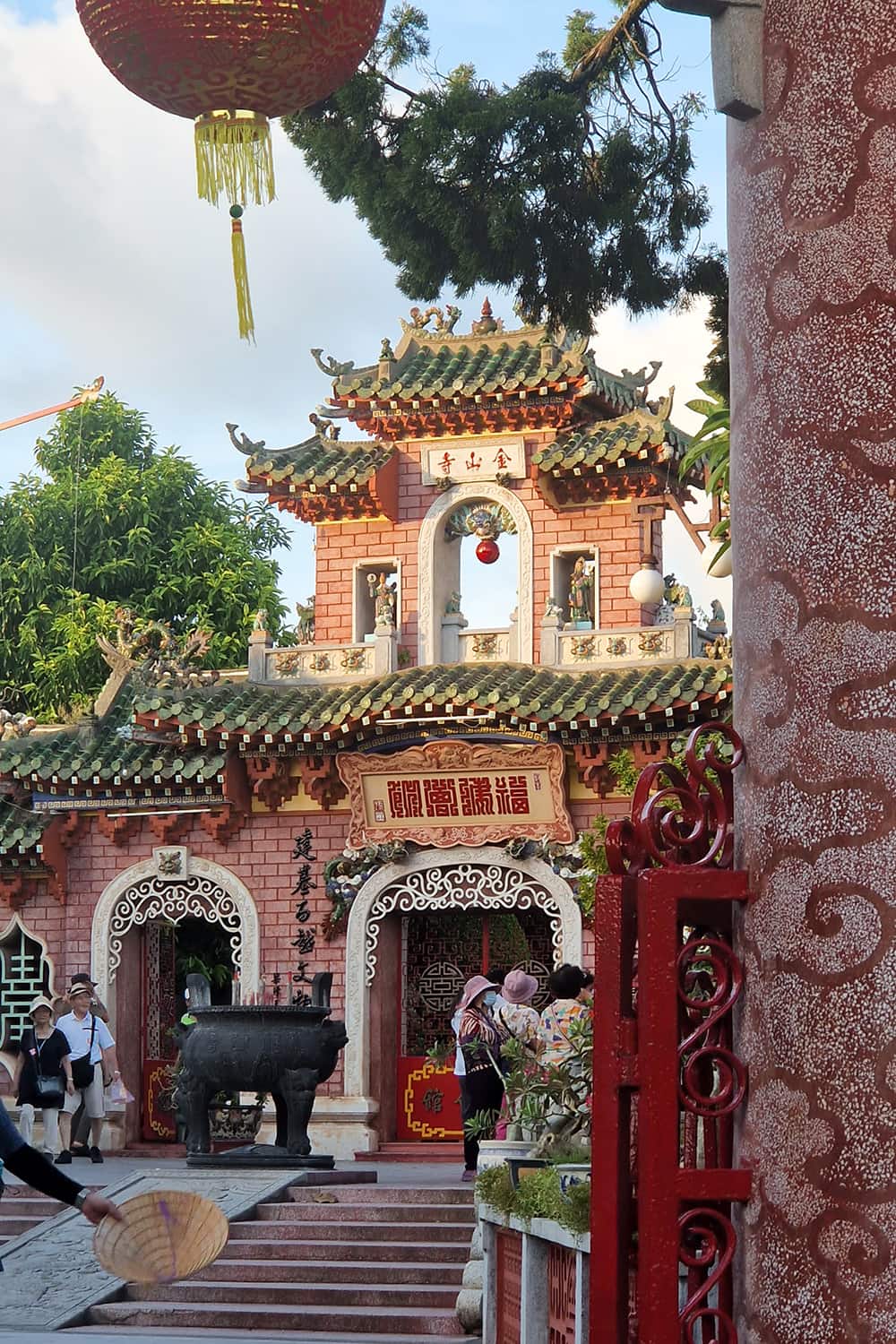 A stunning rose colored gate with a lot of ornaments serving as entry gate to the fujian assembly hall in Hoi-An.