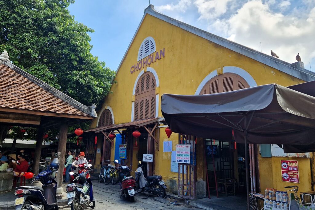 The yellow market hall in Hoi An with a small market also in front of it.