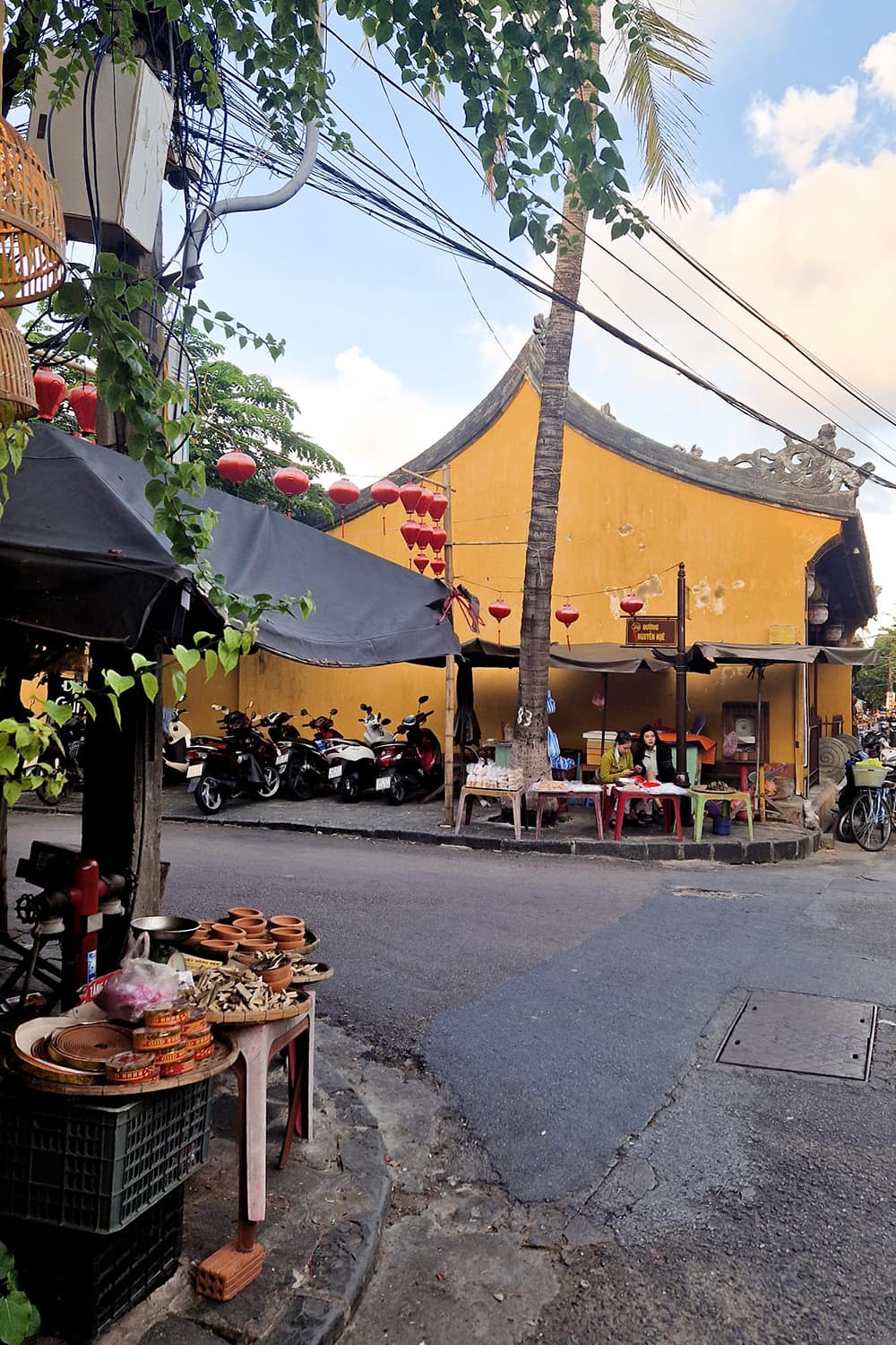 A small intersection in Hoi-An with small resutarants on either side.